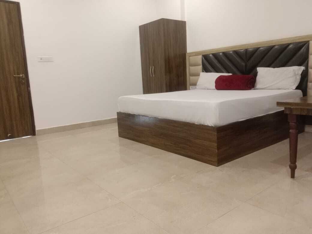 Un dormitorio con una cama, un armario y una mesita de noche.