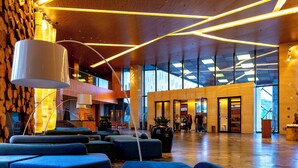 Un vestíbul ampli amb il·luminació moderna, seients confortables i grans finestres.