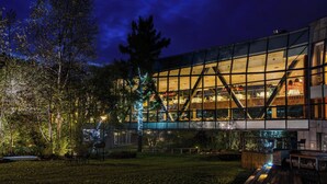 Un edifici modern amb grans finestres de vidre i una zona de fusta.