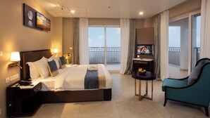 A hotel room with a large bed, a TV, a desk, and a balcony with a view. - Le Crown Hotel (Vagamon)