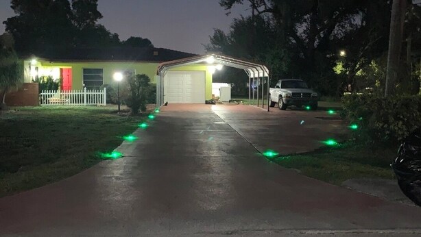 Ein Haus mit überdachter Veranda, Garage und Auffahrt.