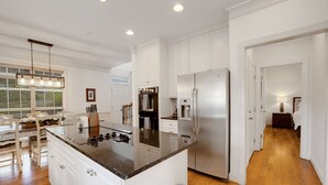 A spacious kitchen with white cabinetry, a granite countertop, and stainless steel appliances. - Augusta Getaway Near Masters Porch Swing Deck (Augusta)