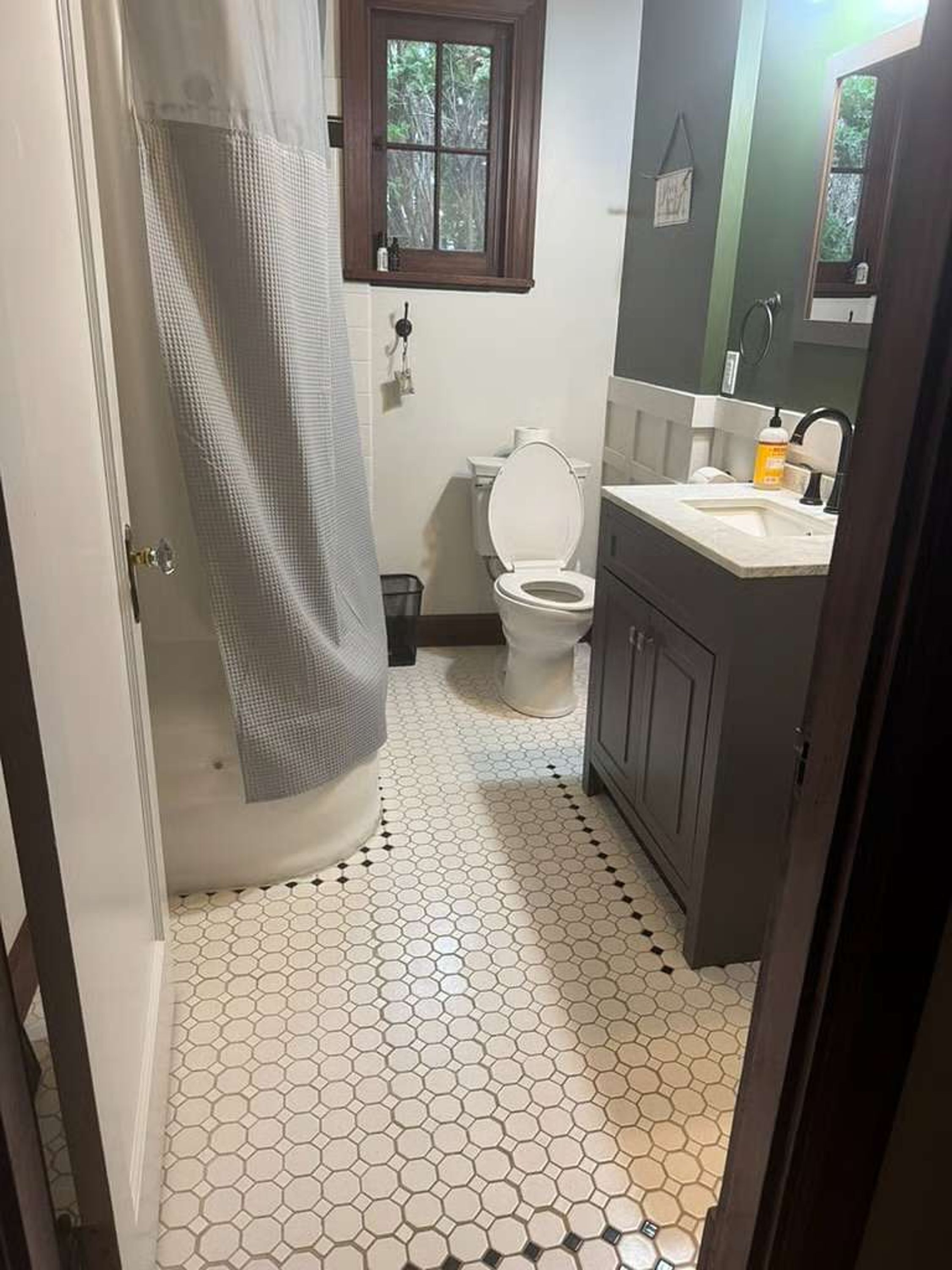 A bathroom with a toilet, sink, and shower area.
