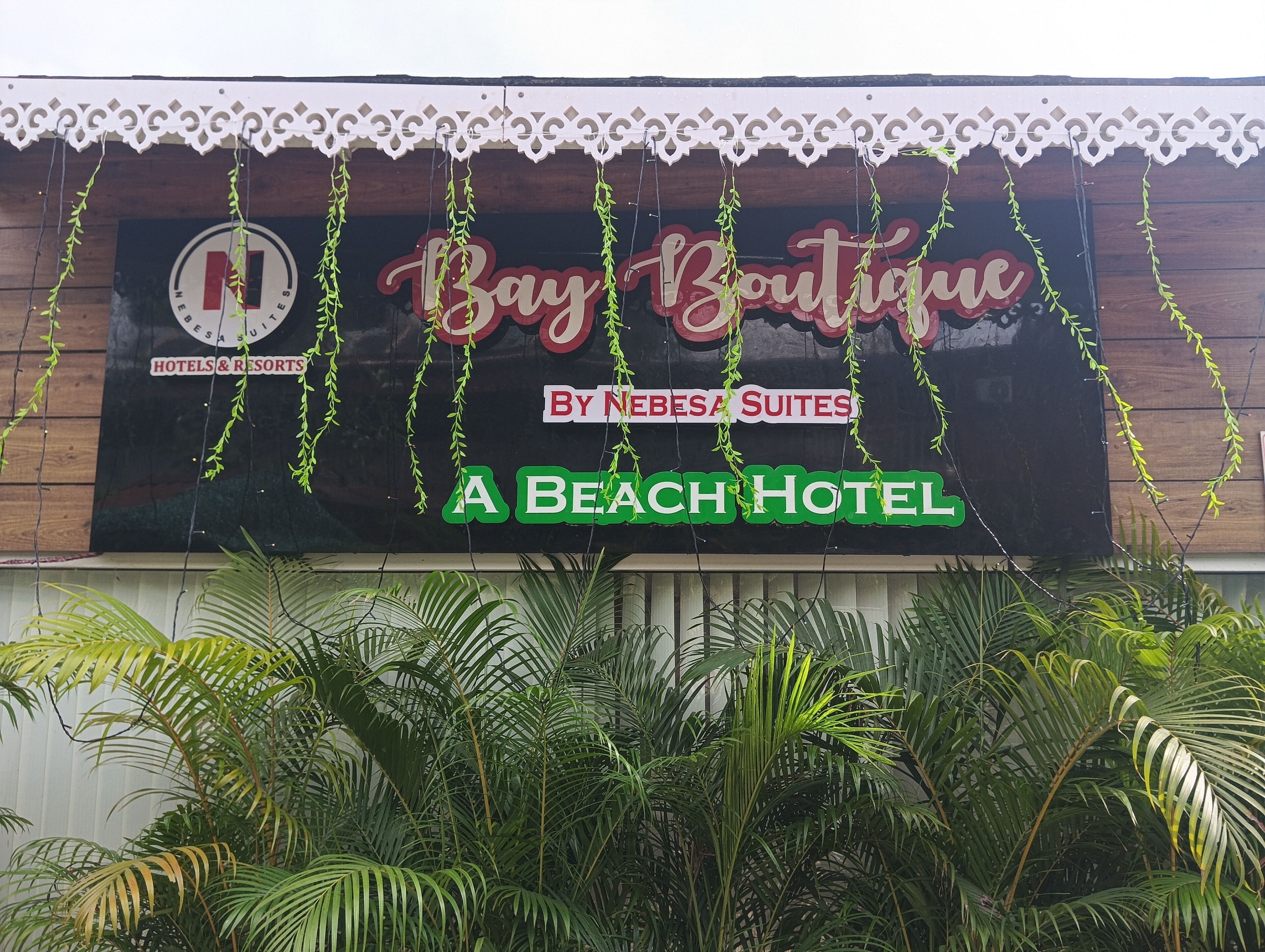 A sign for 'Bay Boutique by Nebesa Suites' indicating it is a beach hotel.