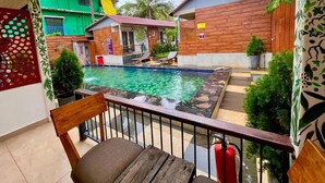 Ein Poolbereich mit Holzterrasse, einem Liegestuhl und einem Feuerlöscher.