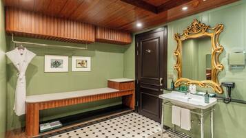 Een badkamer met een houten bankje, een wastafel, een spiegel en kunst aan de muur.