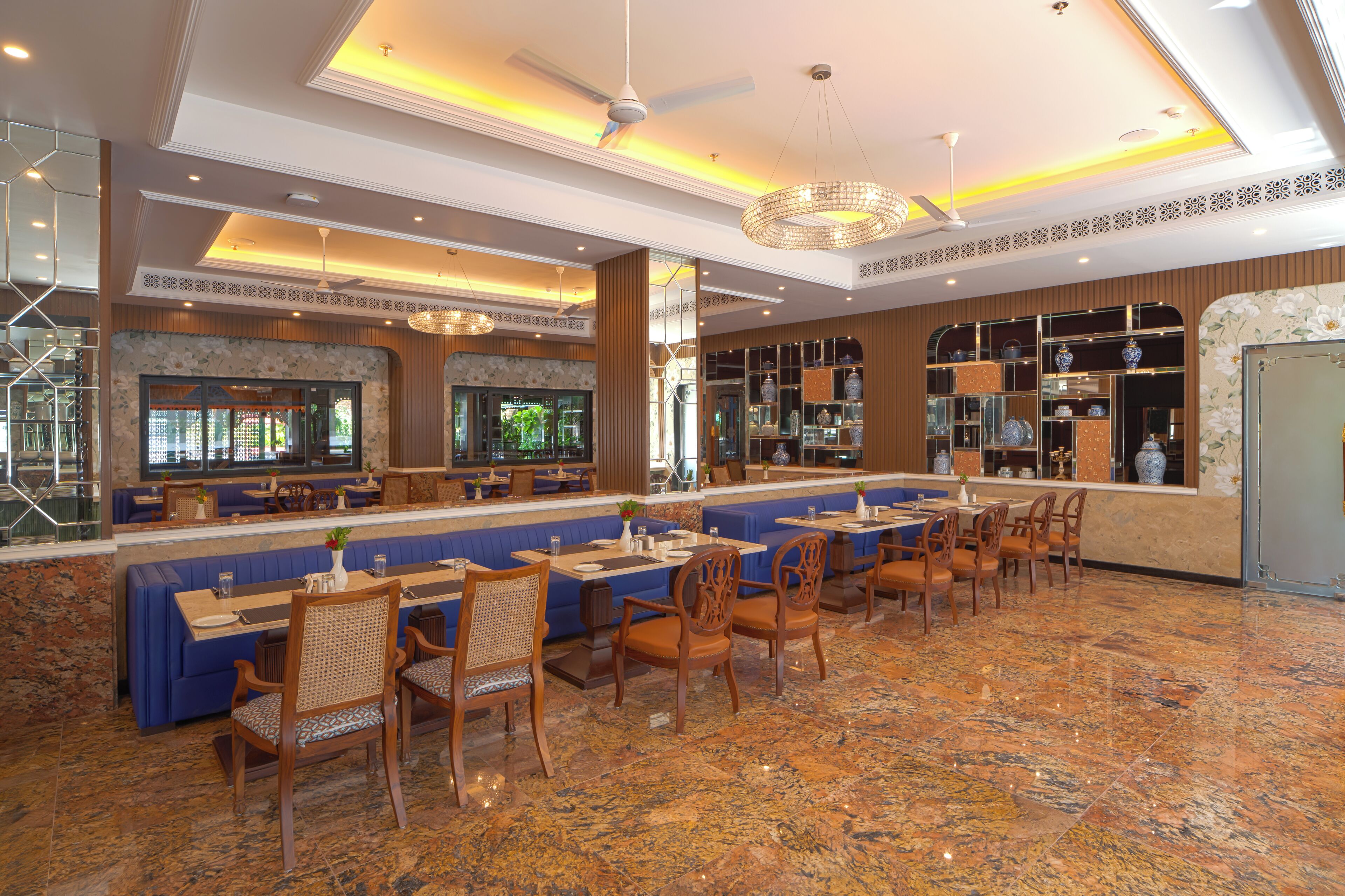 A spacious restaurant with a long counter, multiple seating areas, and a decorative ceiling.