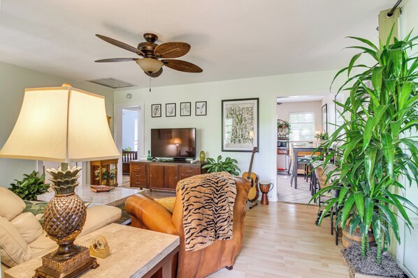 A living room with a ceiling fan, a television, a sofa, a coffee table, and a potted plant. - Gateway to the Everglades! Tropical Jungle Cottage (Miami)