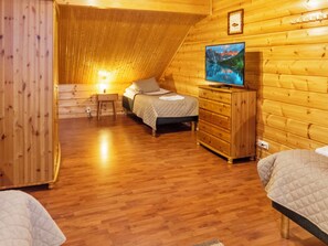 Een knus ingerichte kamer met een bed, een dressoir en een televisie.
