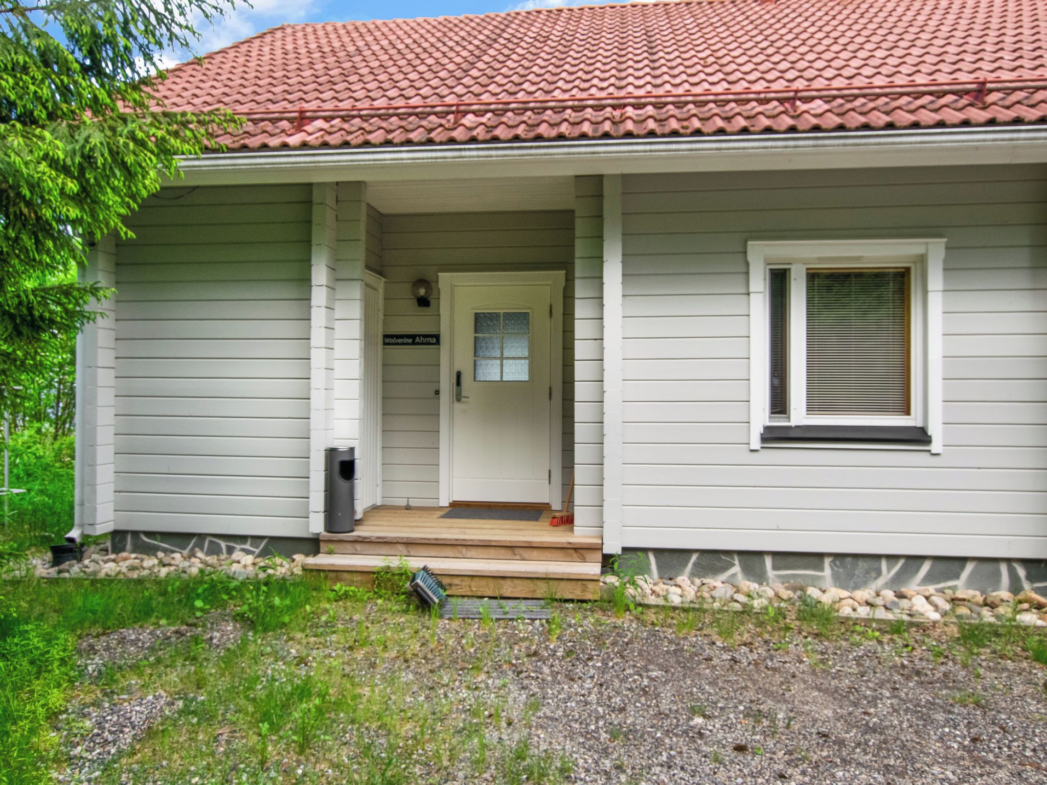 A single-story house with a front porch, a door with a window, and a small window on the side.