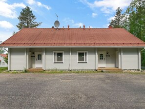 Ein eingeschossiges Haus mit rotem Ziegeldach, weißer Fassade und einer Satellitenschüssel.