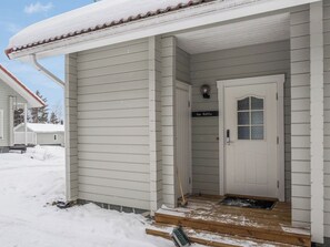 Un bâtiment blanc avec une porte portant l’inscription « Fox Kettu » et un petit porche.