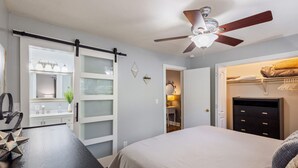 A bedroom with a bed, a dresser, a vanity with a mirror, and a ceiling fan. - Hot Tub BBQ Retreat Spacious Backyard Pet-friendly (North Augusta)