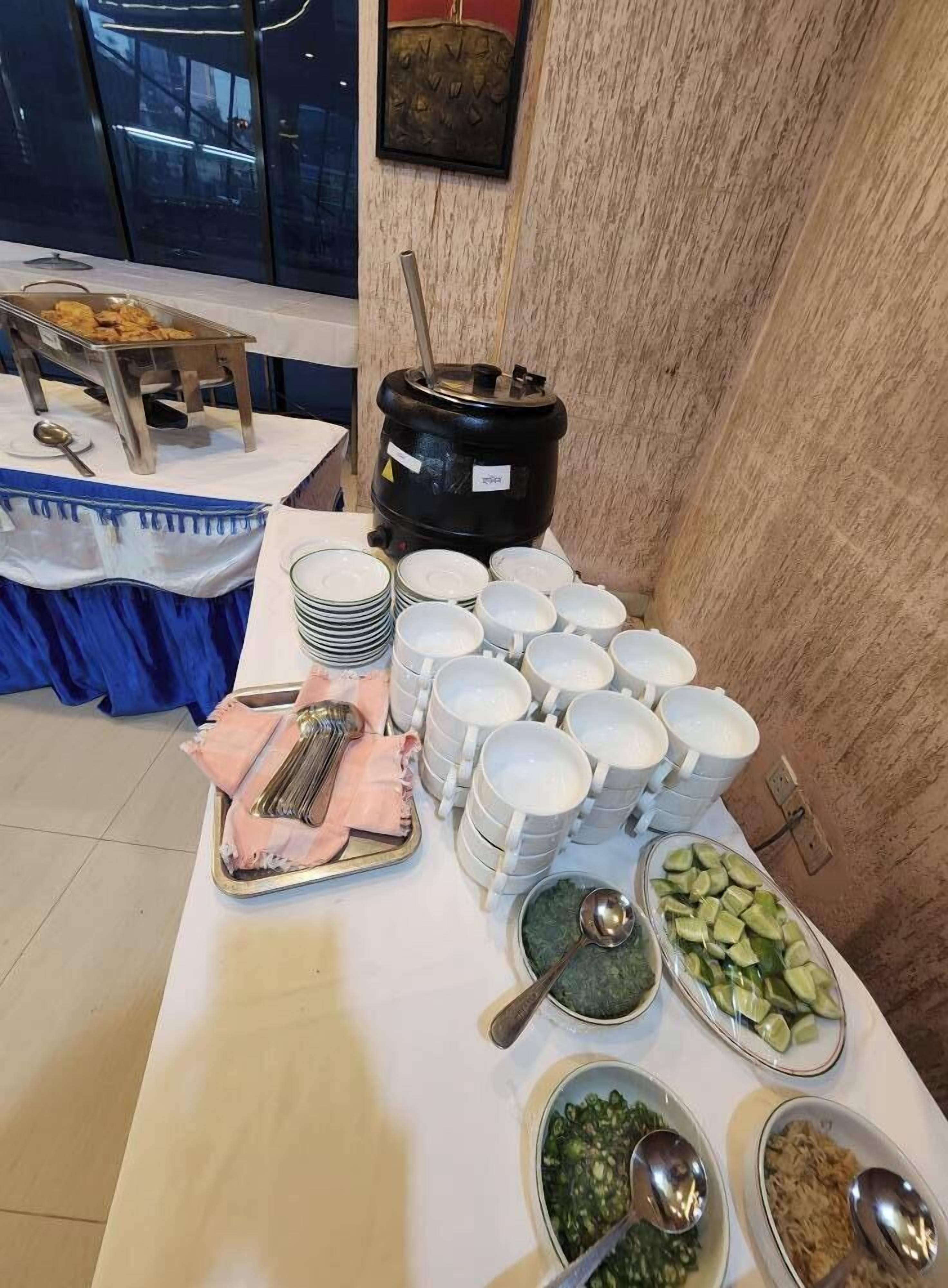 A buffet setup with various food items and utensils.