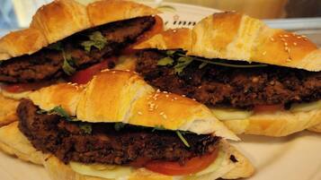 A plate with three sandwiches, each cut in half, revealing layers of meat, vegetables, and sauce.