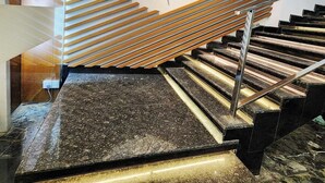 A modern staircase with a unique wooden slat design and a central decorative element. - City Inn Limited Khulna (Khulna)