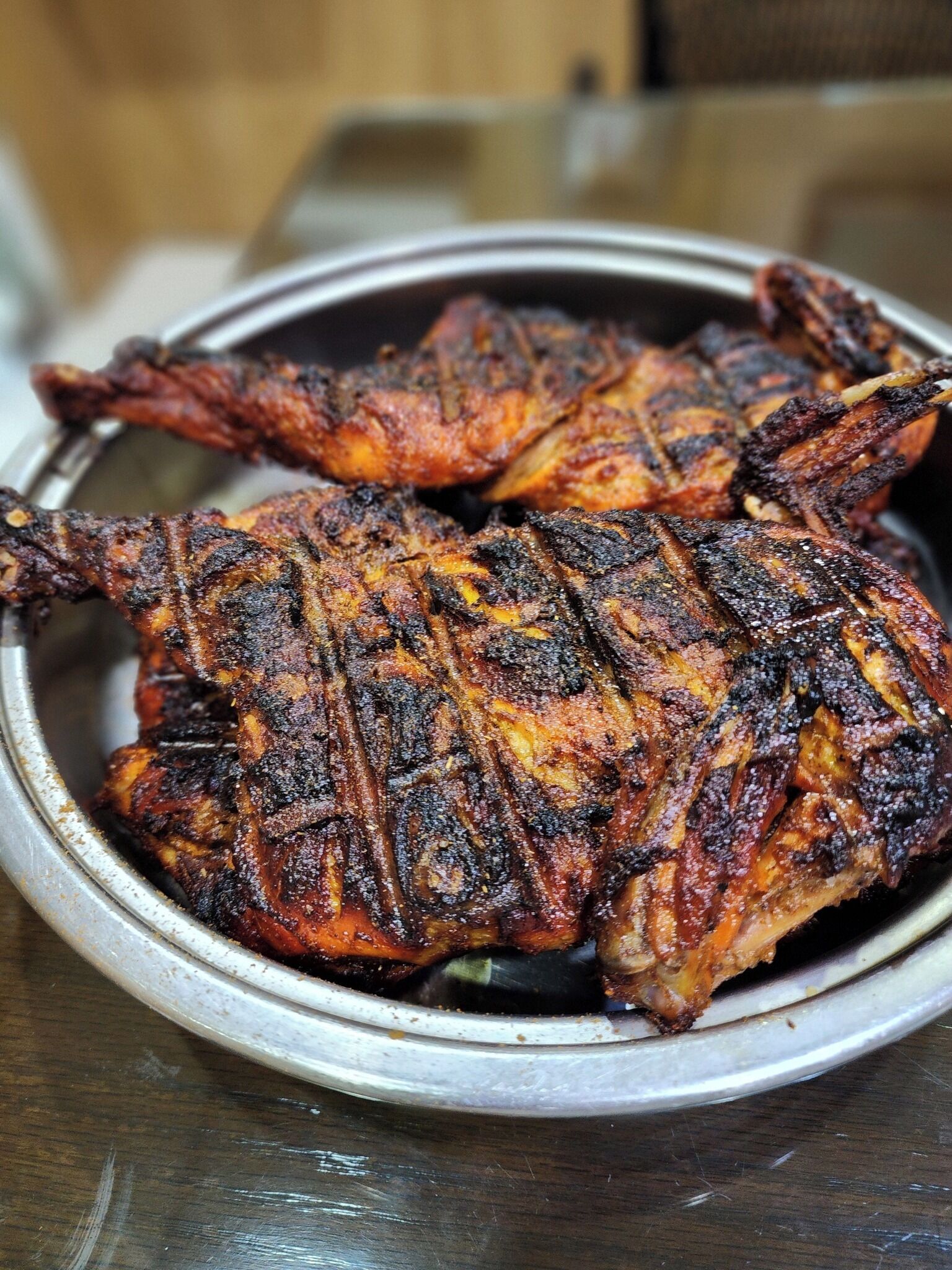 A metal plate with grilled chicken legs.