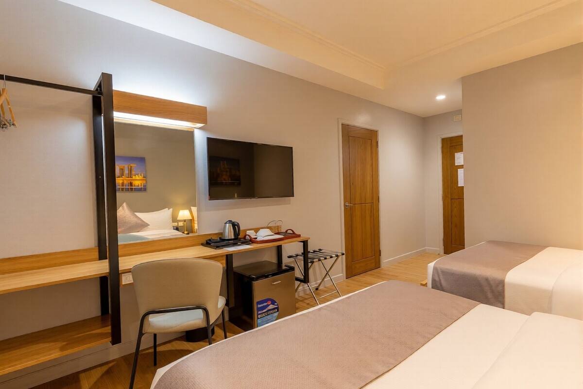 Une chambre d’hôtel comprenant un lit, un bureau avec une chaise, une télévision, une armoire et une porte.