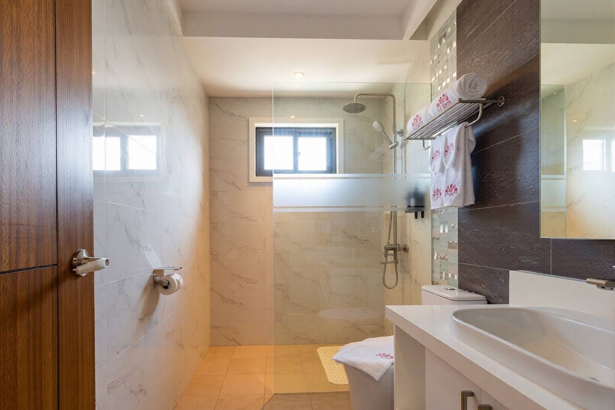 Une salle de bain moderne équipée d’une douche, de toilettes et d’un lavabo.