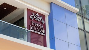 A hotel sign with a bicycle symbol and the name 'Dona Manor Boutique Hotel'. - Doña Manor Boutique Hotel (Olongapo)