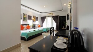 Una habitación de hotel con una cama, una mesa de comedor con hervidor, un sofá y una ventana con cortinas.