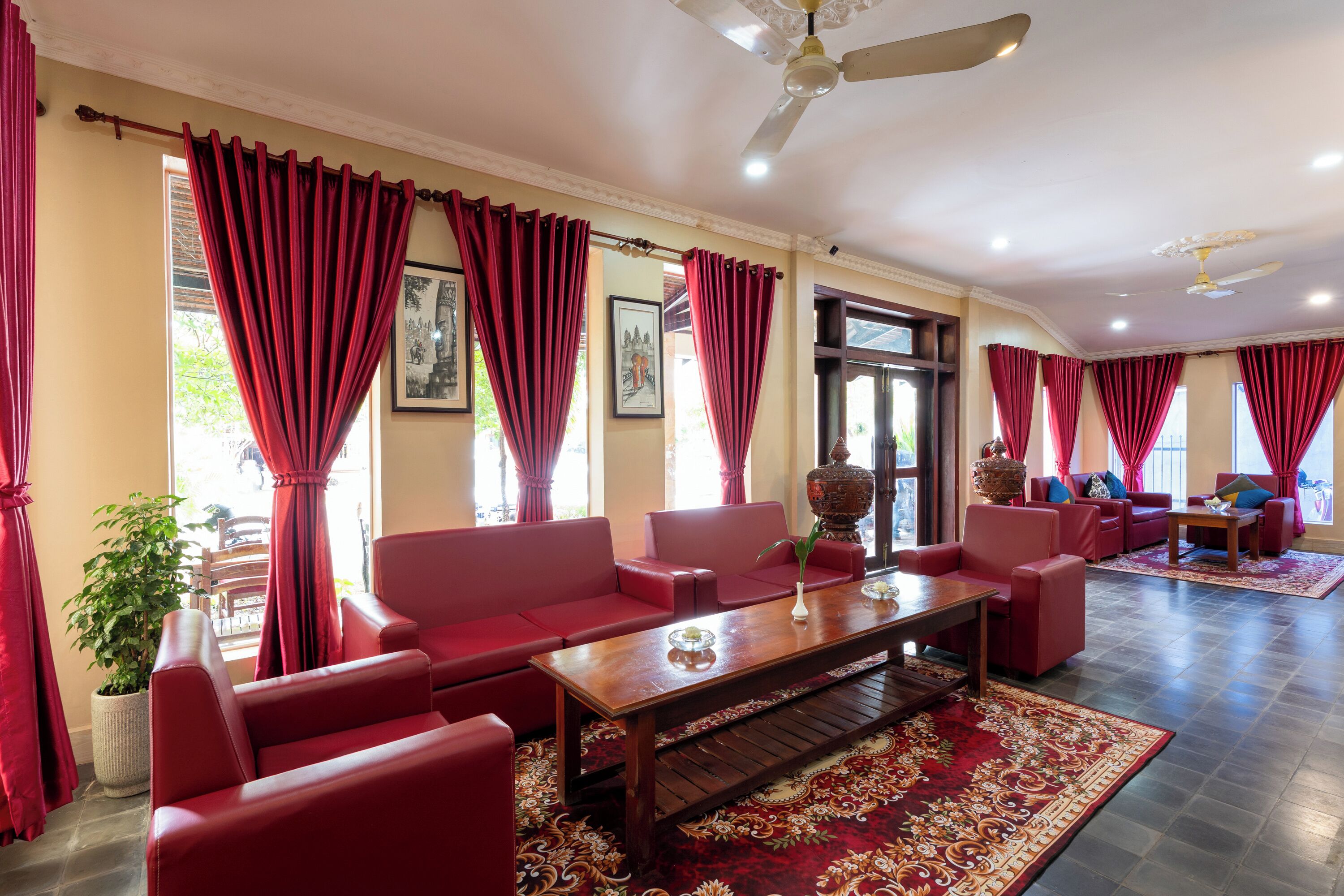 A spacious living room with red sofas, a wooden coffee table, and a large red rug.