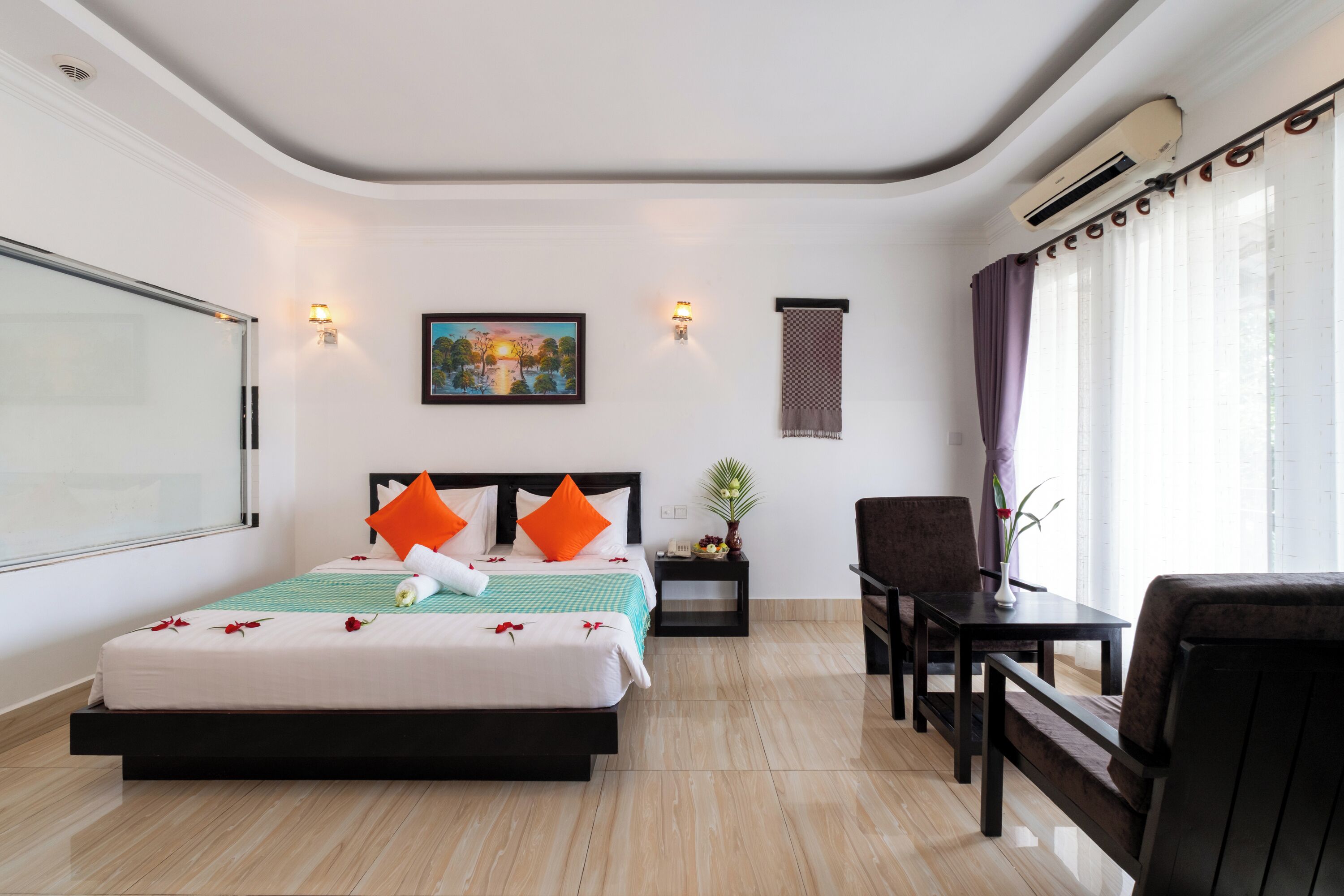 Une chambre d’hôtel avec un lit, une table de chevet, une chaise et une fenêtre avec des rideaux.