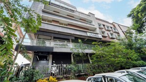 Un immeuble à plusieurs étages doté de balcons, d’une entrée couverte et d’un espace de stationnement.