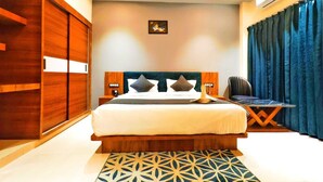 A modern hotel room with a large bed, wooden wardrobe, and a ceiling fan. - Hotel The Crystal (Māvli)
