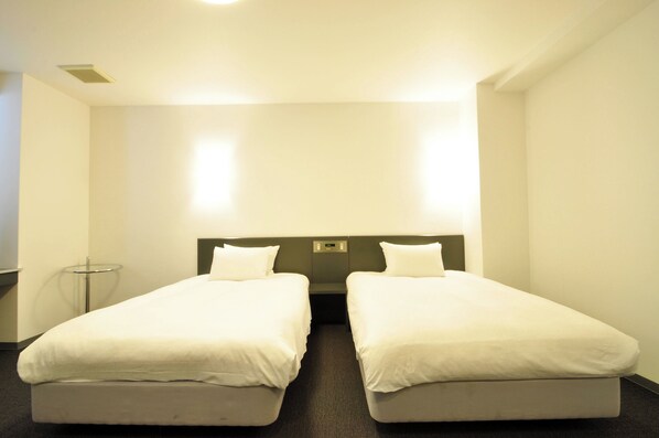 A hotel room with two single beds, a bedside table, and a lamp. - THE AGNES HOTEL TOKUSHIMA (Tokushima)