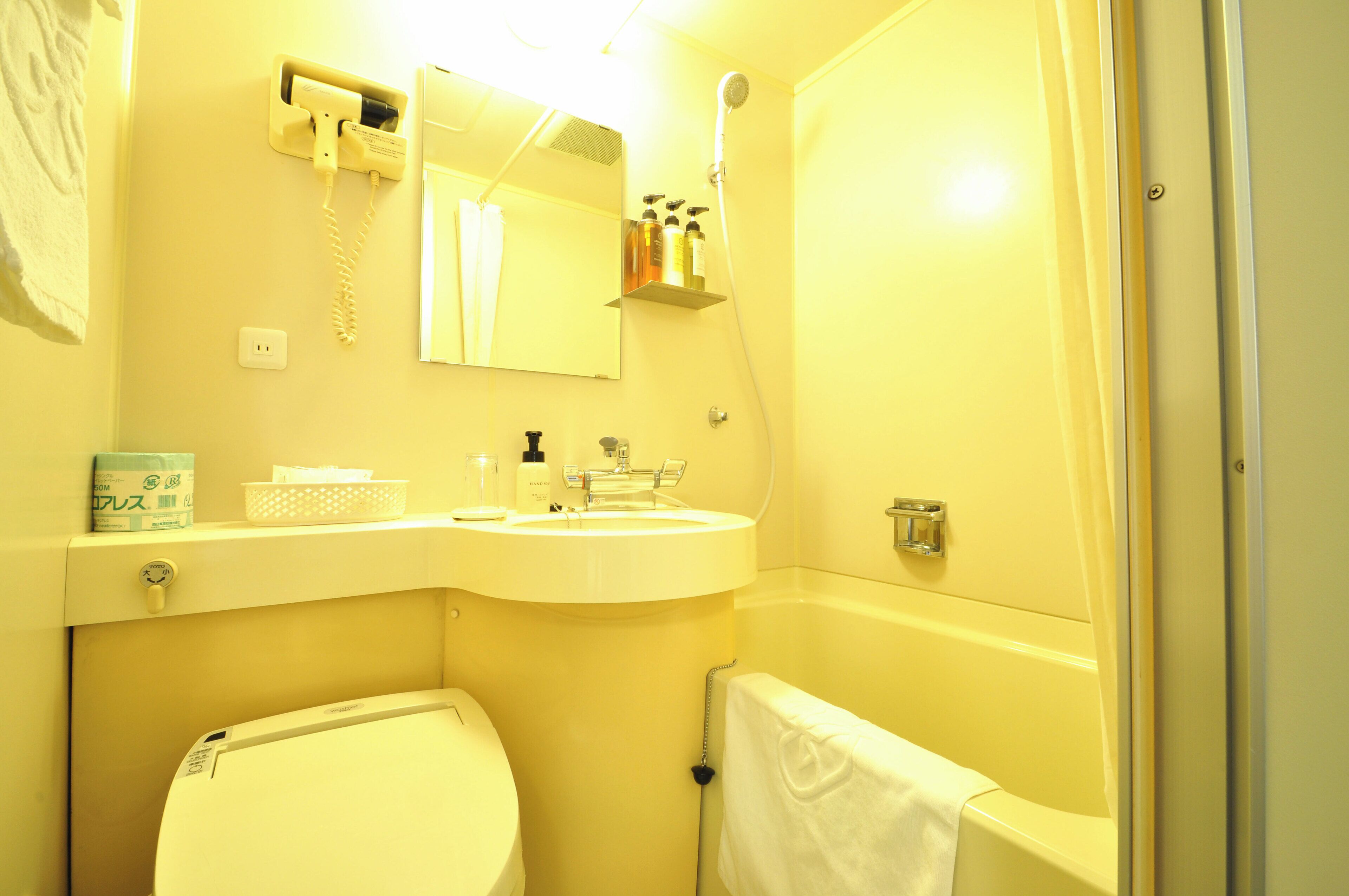 Een badkamer met toilet, wastafel en douche.
