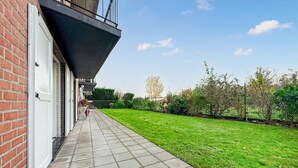 Un chemin menant à un bâtiment à la façade en briques et doté d’une porte de garage.