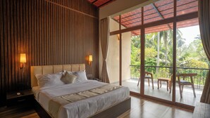 Un dormitorio con una cama grande, paredes de paneles de madera y un balcón con mobiliario exterior.