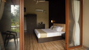 Un dormitorio con cama, mesita de noche, cómoda y balcón.