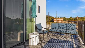 A balcony with a sofa, chairs, and a small table. - Festive Villa in Richardson/Dallas (Richardson)