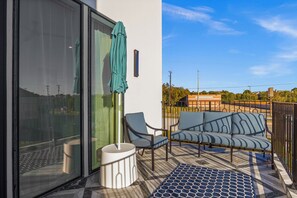 Un balcon avec un canapé, des chaises et une petite table.