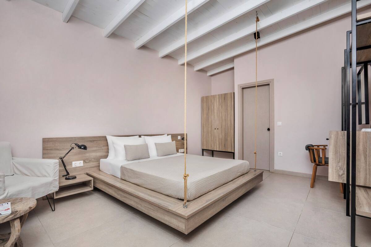 A modern bedroom with a wooden bed, a desk, a chair, and a wardrobe.