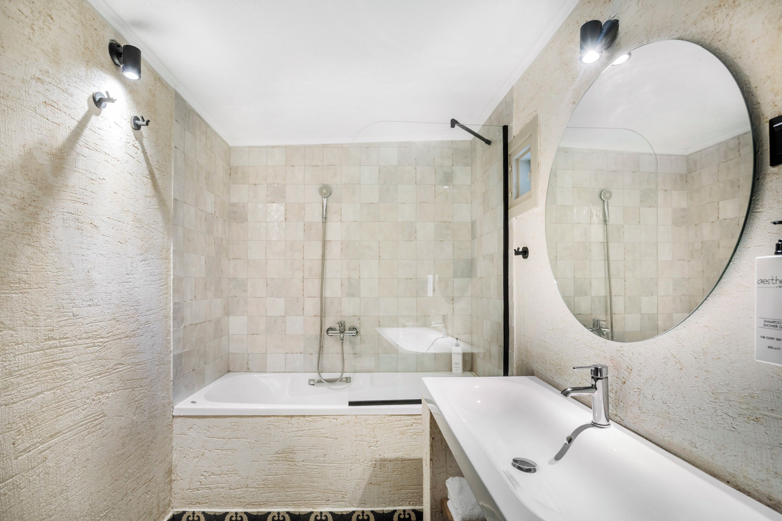 Ein Badezimmer mit einer Badewanne, einem Waschbecken und einem großen Spiegel.