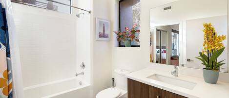 A modern bathroom with a bathtub, toilet, and sink.
