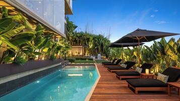 Una piscina al aire libre, tumbonas