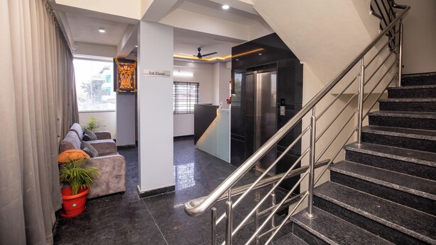 A modern interior with a staircase, a sofa set, and a potted plant. - Hotel Miracle Meridian  (Bengaluru)