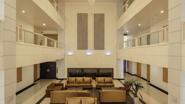 A spacious lobby with a chandelier, seating area, and a reception desk. - Aspira Petchkasem (Krathum Baen)