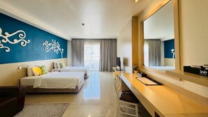 A hotel room with two beds, a desk, a chair, a large mirror, and a decorative wall. - Aspira Petchkasem (Krathum Baen)