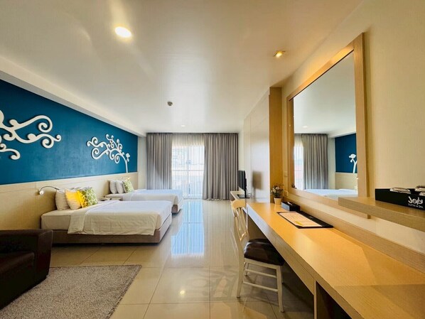 Une chambre d’hôtel avec deux lits, un bureau, une chaise, un grand miroir et un mur décoratif.