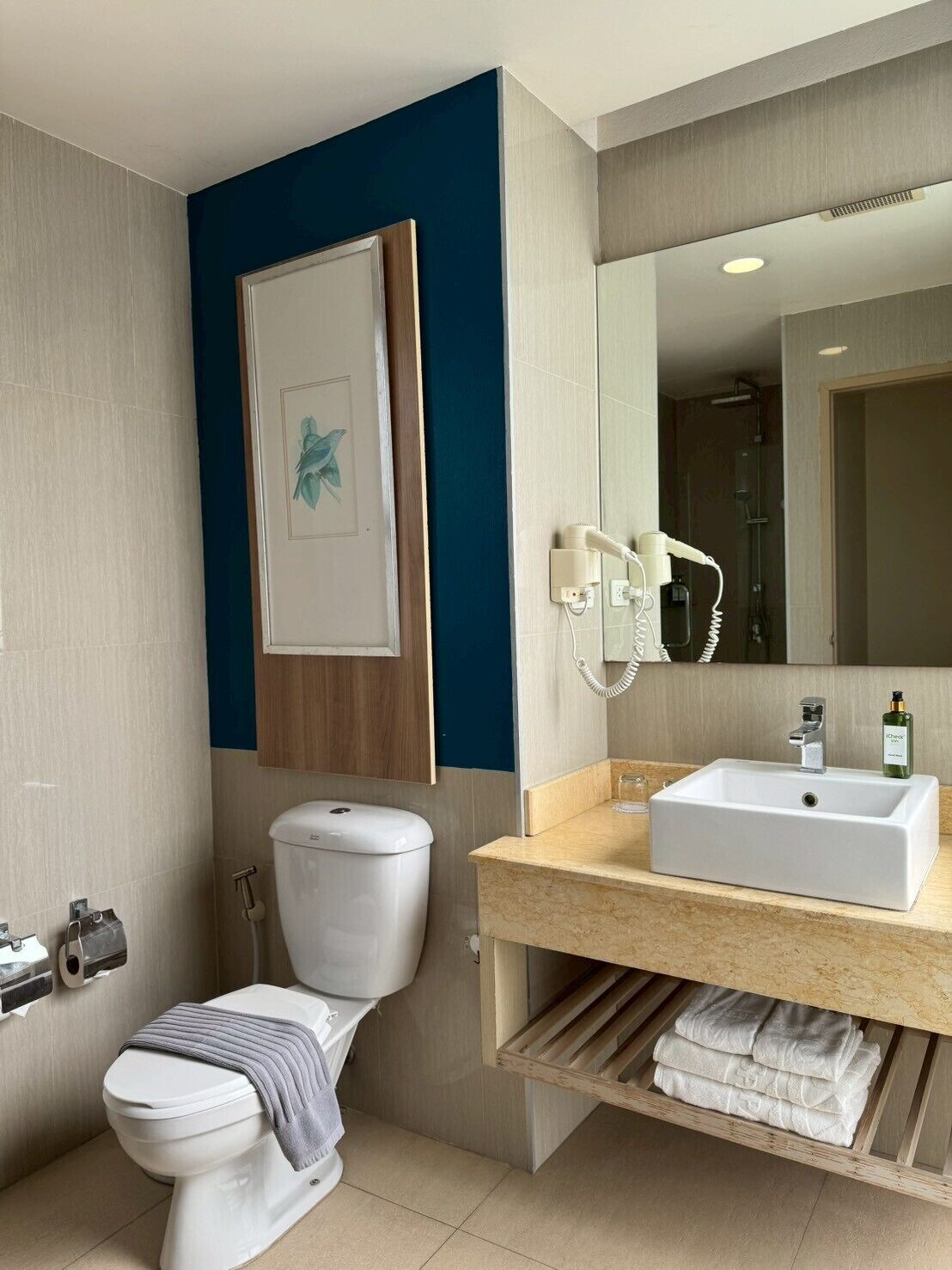 A modern bathroom with a toilet, sink, and shower.