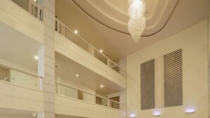 A spacious lobby with multiple seating areas, a large chandelier, and a high ceiling. - Aspira Petchkasem (Krathum Baen)