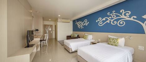 A modern hotel room with two beds, a TV, a desk, and a decorative wall.