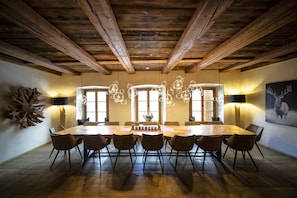 Une salle à manger avec une table en bois, des chaises et un lustre.