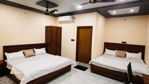 A hotel room with two beds, a ceiling fan, an air conditioning unit, and a marble floor. - Krishna Residency By Vrindavan Stays (Mathura)