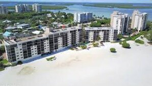 Un hotel costero con varios edificios altos, una playa y vegetación circundante.